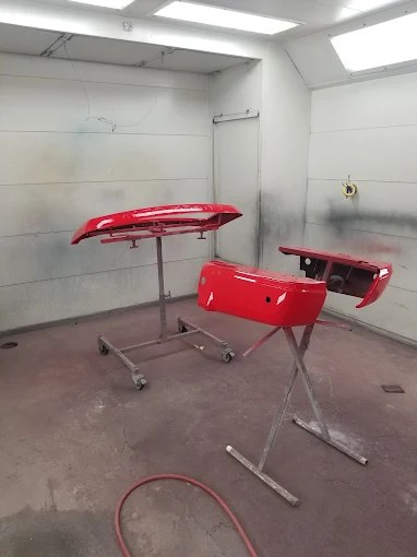 Red bumpers being refinished in the paint booth